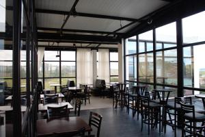 a dining room with tables and chairs and windows at Boulevard Jaguari in Igaratá