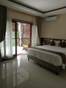 Un pat sau paturi într-o cameră la The Surya Kuta Villa