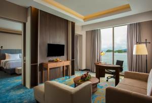 a hotel room with a bed and a desk and a television at Swiss-Belhotel Papua in Jayapura