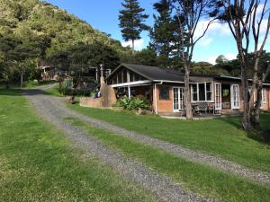 une maison avec une route en gravier devant elle dans l'établissement Heartland Eco Retreat, à Ahipara