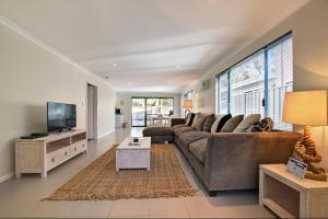 a living room with a couch and a tv at A Little Luxury in Town in Dunsborough