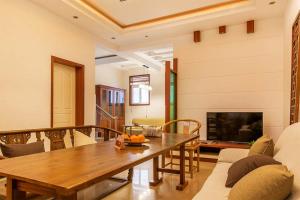 uma sala de estar com uma mesa de madeira e uma televisão em Henan Kaifeng·Millennium City· Locals Apartment 00139400 em Kaifeng