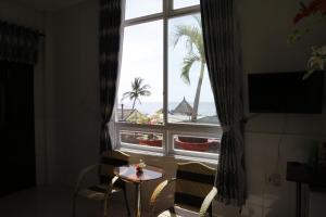 a room with a window with a table and chairs at Minh Hung Hotel in Mui Ne