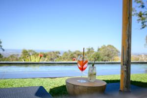 a glass of wine on a table with a view of the water at Spicers Sangoma Retreat - Adults Only in Kurrajong