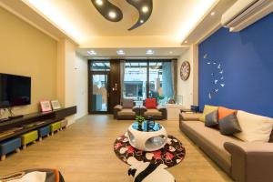 een woonkamer met een bank en een tv bij Tiangong Super Inn homestay in Hengchun