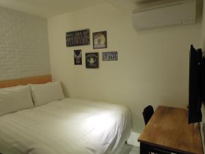 a bedroom with a bed and a desk and pictures on the wall at Re-Change Hotel Taipei in Taipei