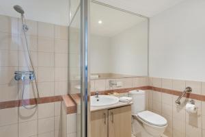 a bathroom with a shower, toilet and sink at The Peninsula Riverside Serviced Apartments in Perth