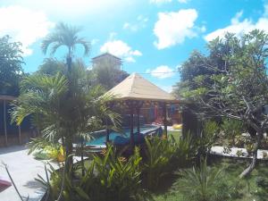 un complejo con piscina y palmeras en Canggu Pinpoint Rooms, en Canggu