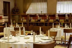 a dining room with tables and chairs with white table linens at Hotel Jozef in Idrija