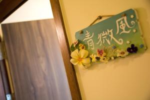 een bord op een muur met bloemen erop bij Tiangong Super Inn homestay in Hengchun