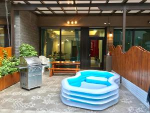 een patio met een blauwe poef en een grill bij Tiangong Super Inn homestay in Hengchun