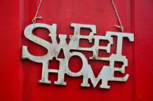 um sinal de metal numa porta vermelha com a palavra asilo em Sweet Home em Dilijan