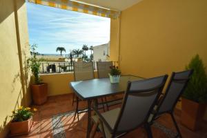 einen Tisch und Stühle auf einem Balkon mit Aussicht in der Unterkunft Cabopino Apartament, Marbella´s Beach in Marbella