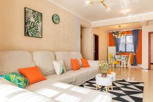 sala de estar con sofá blanco y almohadas de color naranja en Henan Kaifeng·Henan University· Locals Apartment 00140700 en Kaifeng