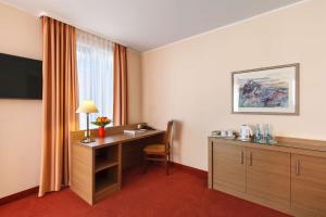 a room with a table, chairs, and a window at Best Western Hotel Bamberg in Bamberg