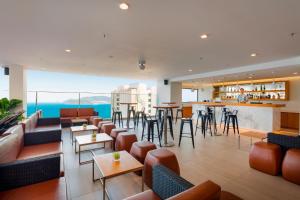 a hotel lobby with tables and chairs and a bar at Nagar Hotel Nha Trang in Nha Trang