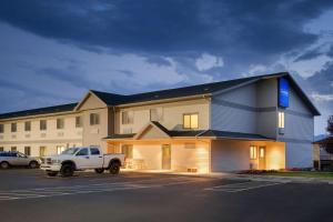 un edificio con un camion bianco parcheggiato in un parcheggio di Travelodge by Wyndham Milford a Milford