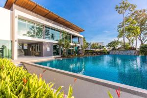 an external view of a house with a swimming pool at Wyndham Grand Phuket Kalim Bay in Patong Beach