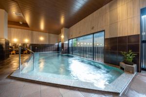 a swimming pool in a building with a building at GRANDVRIO HOTEL NARA -WAKURA- -ROUTE INN HOTELS- in Tenri