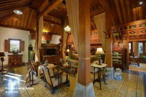 uma sala de estar com um sofá e uma mesa em Ubud Syailendra Heritage Villas by EPS em Ubud