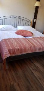 Una cama con una almohada rosa encima. en Hotel am Untreusee en Hof