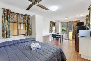 1 dormitorio con 1 cama con 2 toallas en First City Caravilla, en Cairns