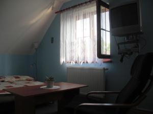 
a room with a bed, chair and a window at Pension Olga in Klecany
