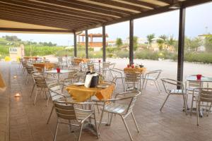 un grupo de mesas y sillas en un patio en Le Fiabe Hotel Resort, en Numana