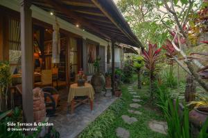 a patio of a house with a table and some plants at Ubud Syailendra Villas in Ubud