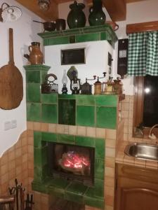 a fireplace in a kitchen with green tile at Apartma Lipek in Pristava