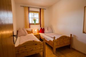 2 Einzelbetten in einem Zimmer mit Fenster in der Unterkunft Apartment Bauernhof Thurnummerstall in Hollersbach im Pinzgau