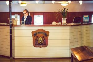 
a man standing in front of a counter in a restaurant at Hotel Barken Viking in Gothenburg
