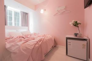 a pink bedroom with a bed and a table at MJ Stay 2 in Seoul