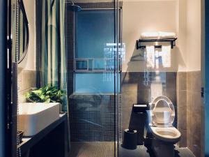 a bathroom with a toilet and a sink and a shower at Huizhou Xilin West Lake Boutique Hotel in Huizhou