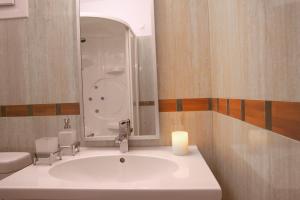 a bathroom with a sink and a mirror at Lagos Mare Hotel in Agios Prokopios
