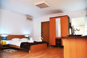 a bedroom with a bed with white sheets and a mirror at ApartHotel Zorilor in Cluj-Napoca