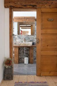 a bathroom with a sink and a wooden door at Rauriser Bergchalet in Rauris