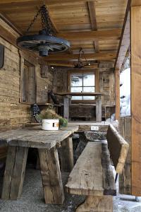 ラウリスにあるRauriser Bergchaletの木製のテーブルとベンチが備わる木造の客室です。