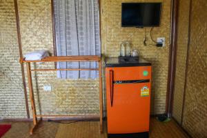 an orange refrigerator in a room with a shelf at Chom Chill Nan in Nan