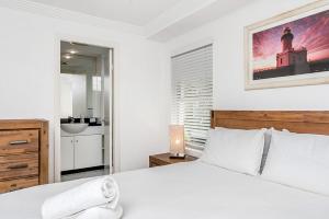 A bed or beds in a room at Byron Bay Accom Unit 4 54 Lawson Street, Byron Bay - The Palms