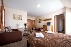 トレボンにあるRodinný hotel Myslivnaのベッドとリビングルームが備わるホテルルームです。