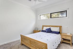 a bedroom with a large bed and a window at Diamond Bay Beach House: brand new in Sorrento