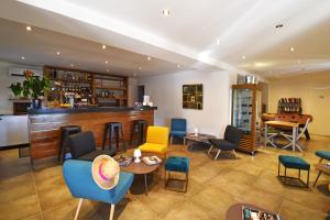 a lobby with a bar with chairs and tables at Bungalows Du Maquis in Porto-Vecchio