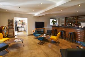 a lobby with a bar with chairs and tables at Bungalows Du Maquis in Porto-Vecchio