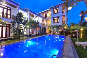 uma piscina em frente a uma casa à noite em Green Hill Villa em Hoi An