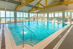 ein großes Hallenbad mit blauem Wasser in der Unterkunft Azureva Hendaye in Hendaye + 37 Fotos