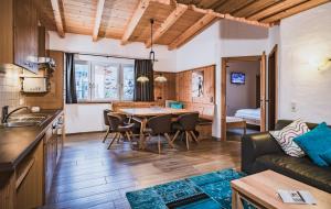 Una cocina y una sala de estar con una mesa y un sofá. en Apartment Margarethenstein mit privat Sauna, en Kaprun