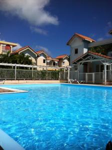 a large blue swimming pool in front of some houses at Appt 2chb avec piscine in Sainte-Anne