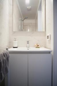 a white bathroom with a sink and a mirror at Villa Giove Rooms in Prato