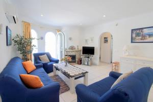 エンプリアブラバにあるLEON INMO Villa Franca - 10049のリビングルーム(青いソファ、テレビ付)